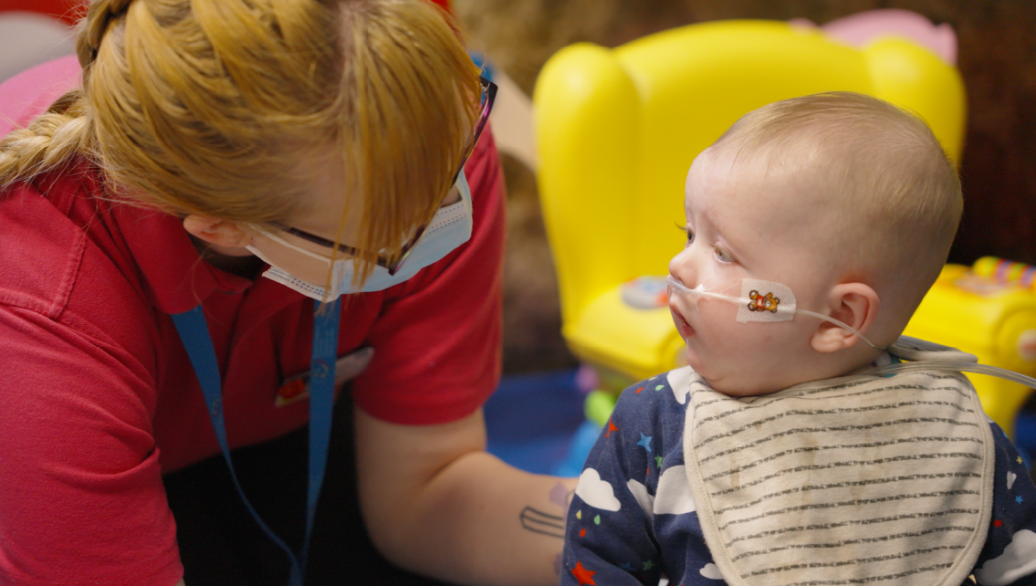 Play specialist with young baby in the play room