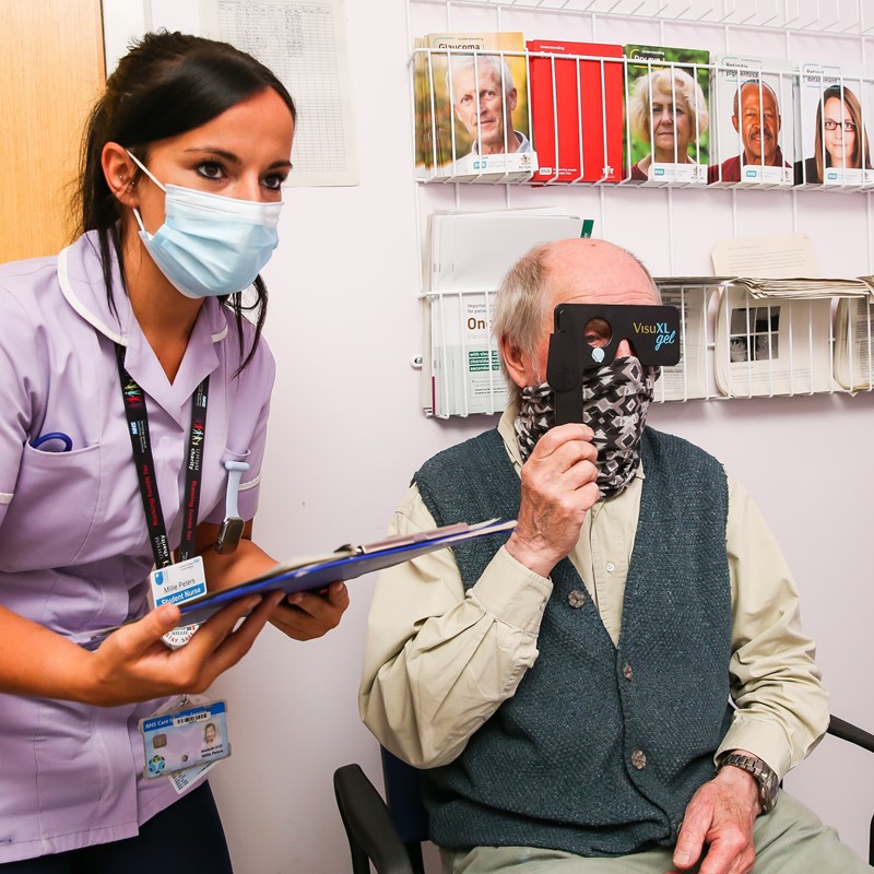 Healthcare talking a patient through an eye test