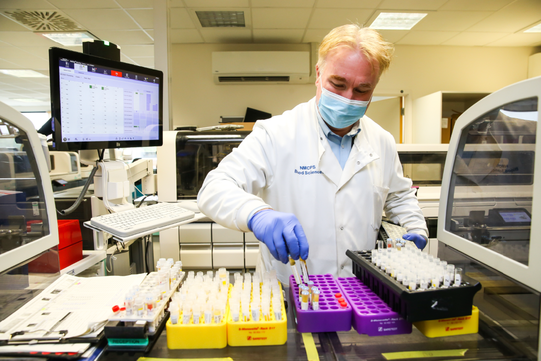 Pathology lab gentleman with test tube trays